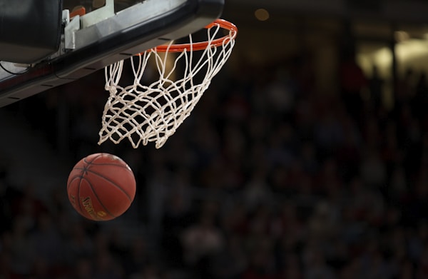 NBA篮球赛场，球员飞身扣篮瞬间，场馆灯光璀璨